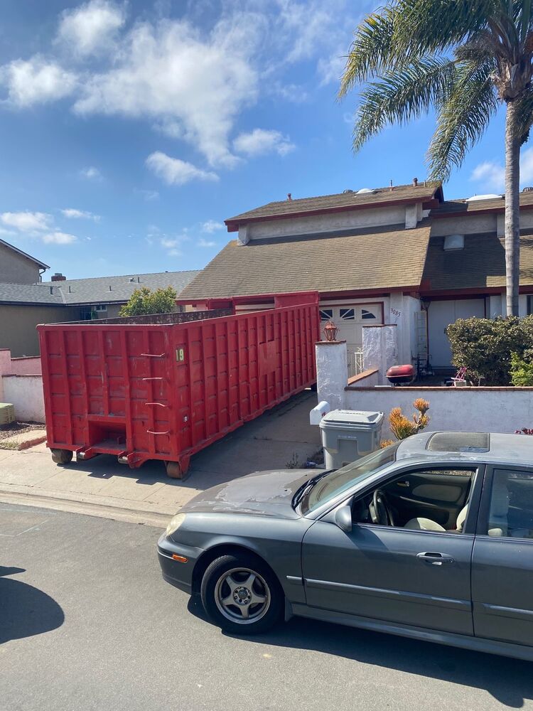 40-yard red Heverly & Sons roll-off dumpster parked curbside at a Serra Mesa home with palm trees