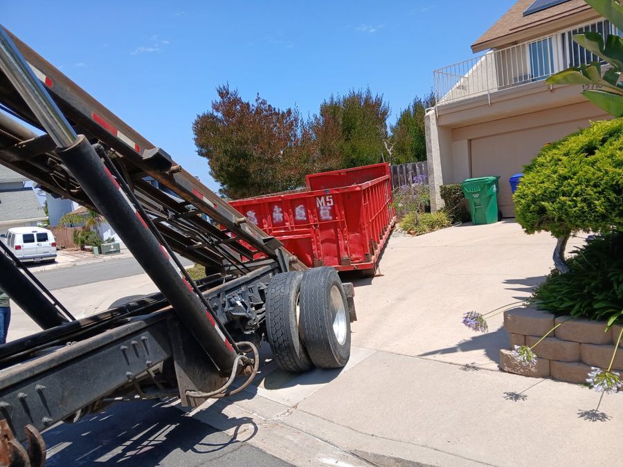 Red 20-yard roll-off dumpster on a Rancho Peñasquitos driveway for a full house cleanout